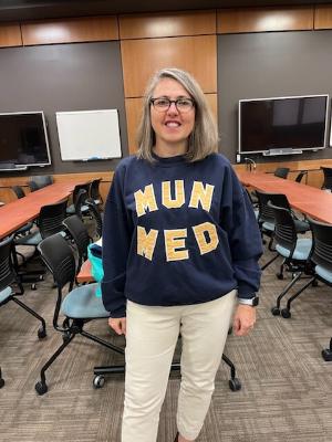Dr. Delores McKeen wears a vintage MUN MED sweatshirt and smiles at Reunion 2022
